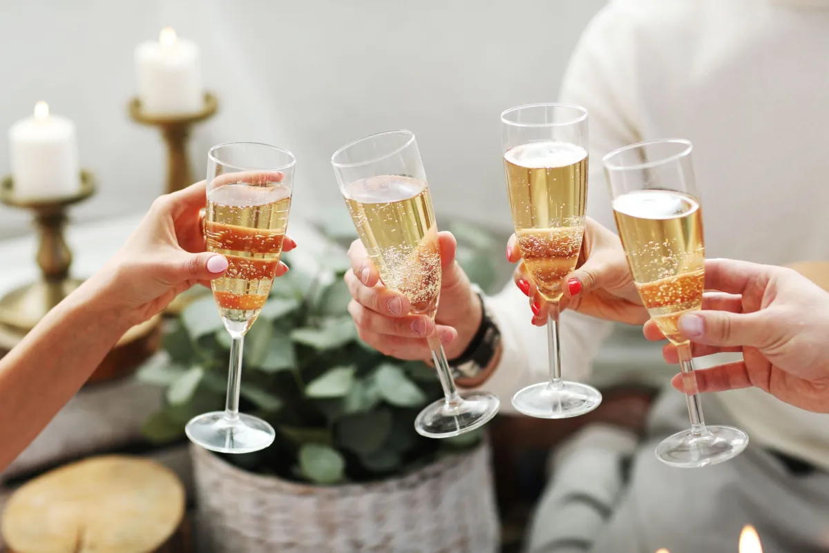 Toast kieliszkami w kilku dłoniach podczas świątecznego spotkania