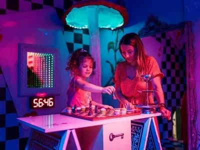 Salon gier, gracze przy automatach w neonowym świetle