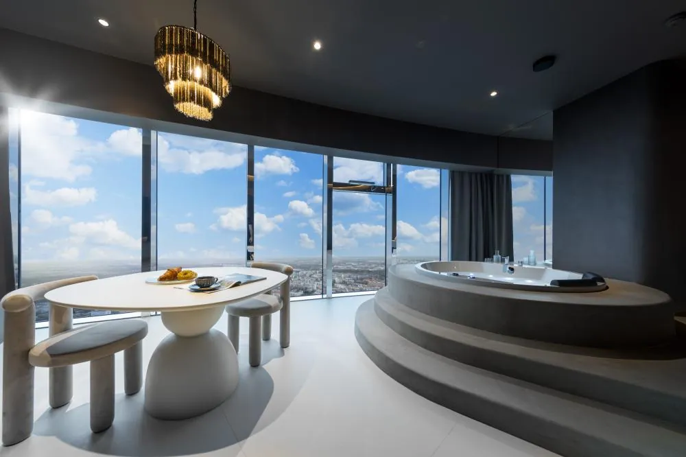 Wnętrze apartamentu In The Sky z okrągłym jacuzzi i stołem, panorama Wrocławia