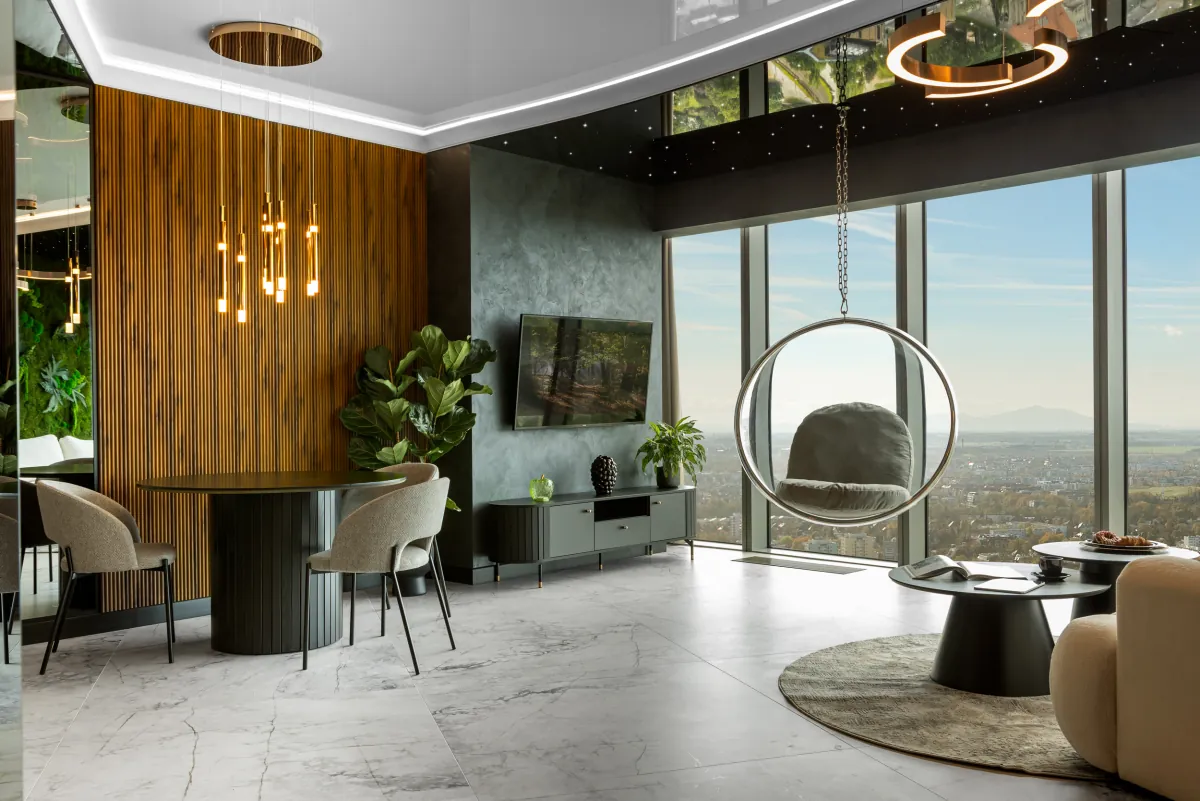Salon apartamentu premium In The Sky, fotel wiszący i panorama Wrocławia za szybą