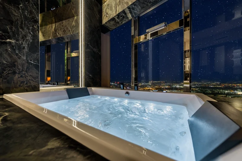 Jacuzzi przy oknie nocą, światła Wrocławia w dole